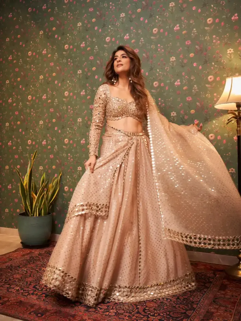 Tahira Kashyap in a champagne-gold lehenga with an embellished blouse and sheer embroidered sleeve