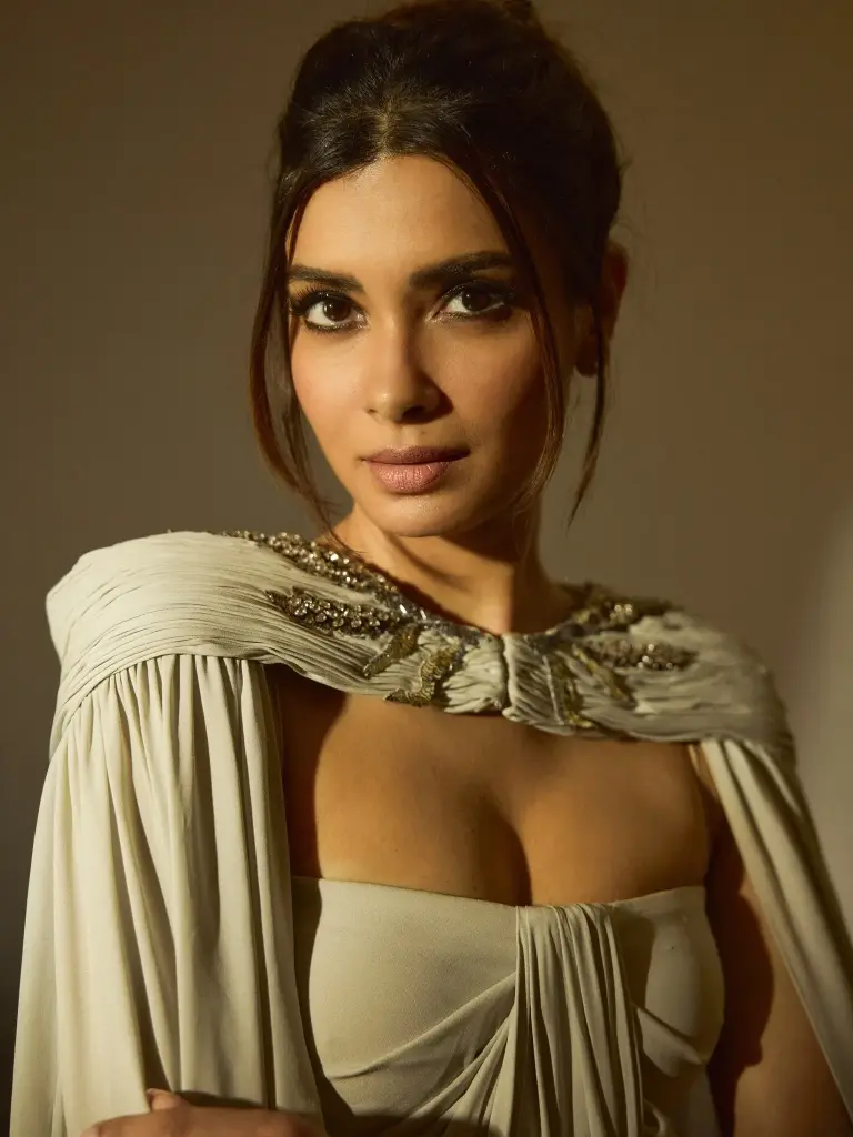 Diana Penty with polished makeup and a high bun complementing her gown’s sculptural neckline