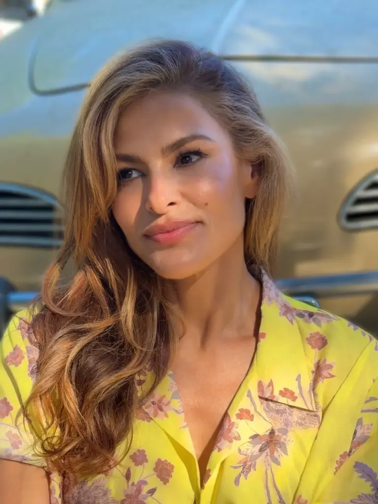 Eva Mendes in a lemon-yellow, short-sleeved button-down with pink, mauve and earthy-toned florals