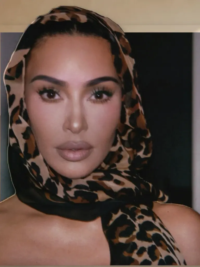 Kim Kardashian wearing a sheer black leopard-illustrated shawl across her shoulders and over her head