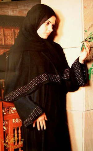 A woman wearing a full-length black abaya draped from the shoulders over her clothing