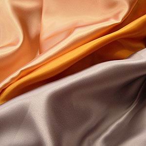 A length of acetate satin fabric showing its characteristic sheen and fluid drape