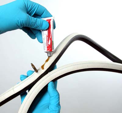 Adhesive being applied from a tube onto a material surface before bonding