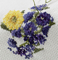 Cross-stitch embroidery worked on Aida cloth showing completed stitches filling the fabric grid