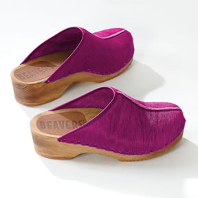 A pair of pink clogs with a solid raised sole and high covered vamp