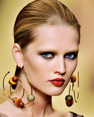 Large statement earrings worn close to the face