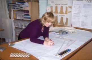 A pattern maker working on garment patterns